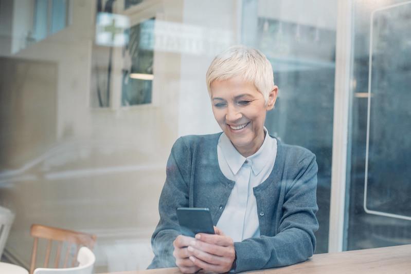 bilde som viser kunde med mobiltelefon på kafe - Klikk for stort bilde