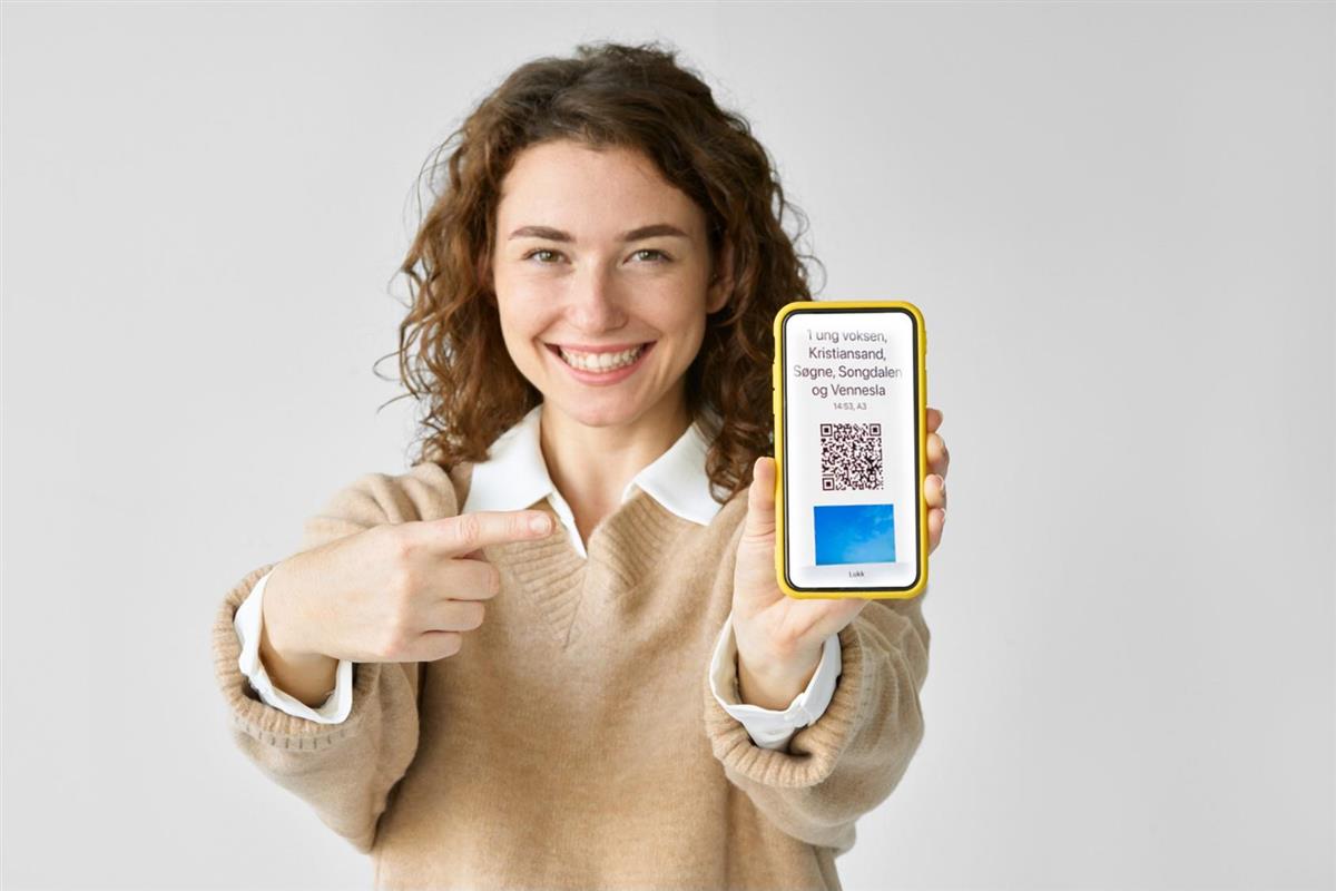 bilde av kvinne som viser frem QR-kode på mobilbilletten - Klikk for stort bilde